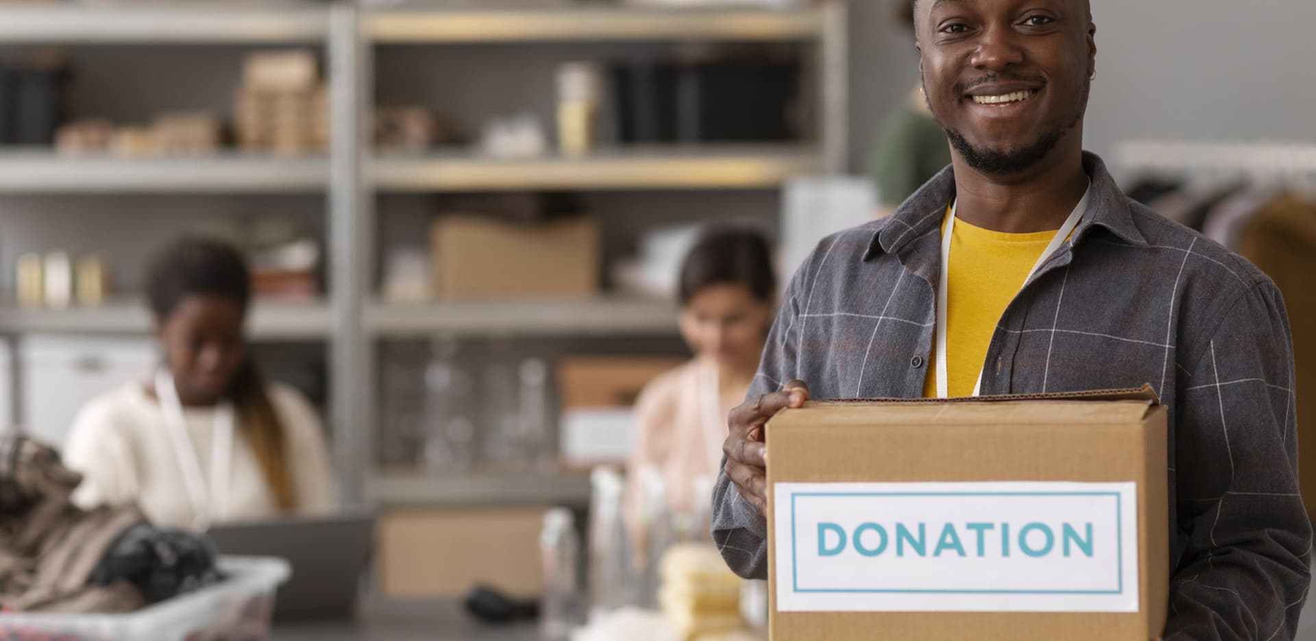 A volunteer holding a box of donated food and supplies